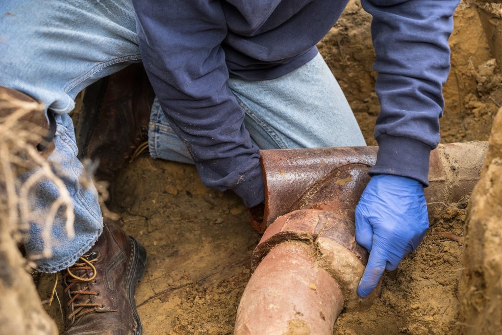 man working on pipes in order to work on backflow prevention