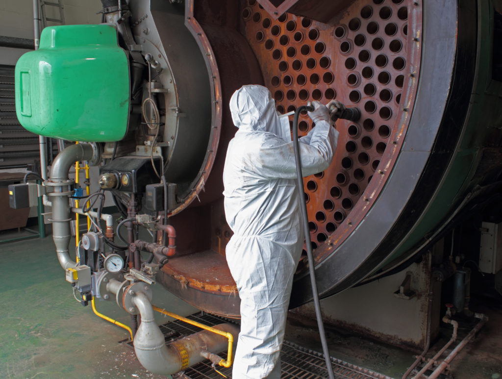 a man cleaning a large industrial machine