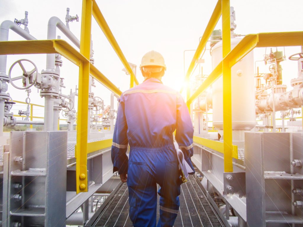 worker walking through a oil and gas refinery